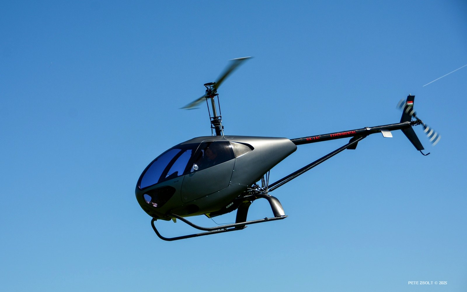 HC-02 im Flug vor hügeliger Landschaft